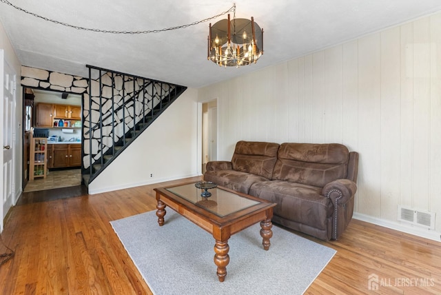 living room featuring hardwood / wood-style flooring and an inviting chandelier