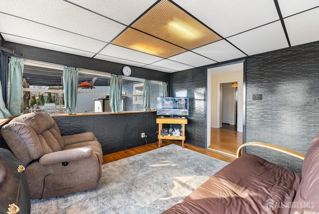 living room featuring hardwood / wood-style floors and a paneled ceiling