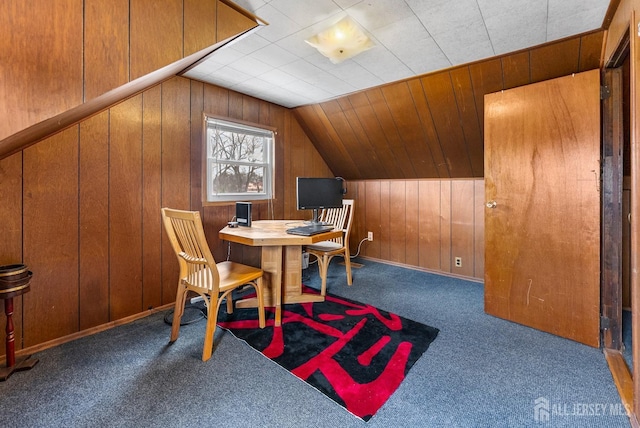 dining area featuring carpet floors, wooden walls, and vaulted ceiling