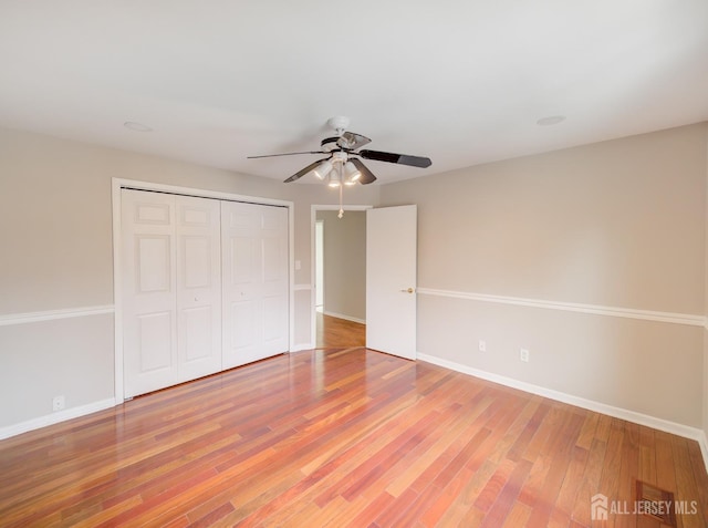 unfurnished bedroom featuring light wood-style floors, a closet, and baseboards