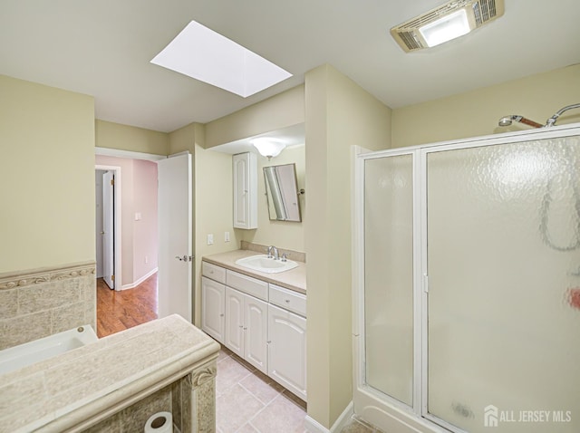 full bath with a skylight, a shower stall, visible vents, and vanity