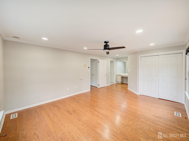 unfurnished bedroom featuring crown molding, baseboards, and light wood-style floors