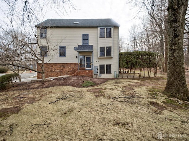 rear view of property with brick siding