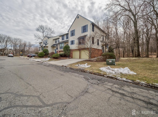 view of home's exterior featuring a garage, concrete driveway, and brick siding