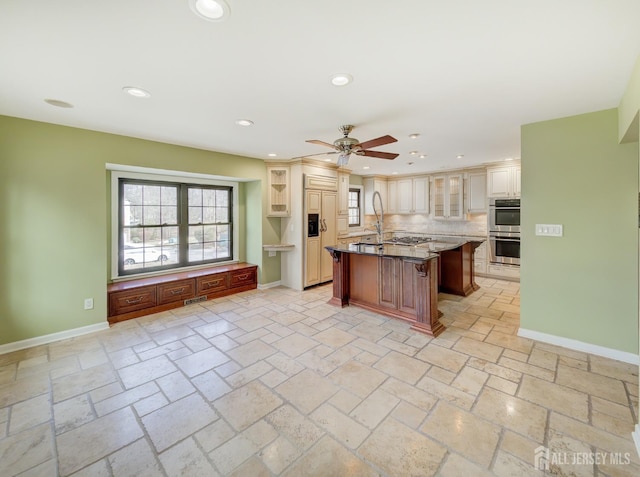 kitchen with recessed lighting, baseboards, a kitchen breakfast bar, appliances with stainless steel finishes, and tasteful backsplash