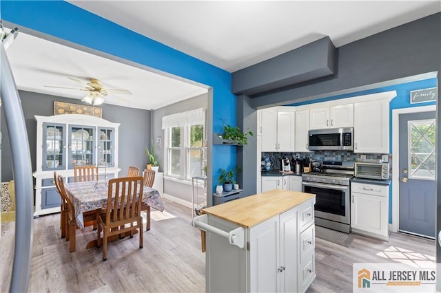 6 Hermann St, Carteret, NJ 07008 - kitchen with appliances with stainless steel finishes, tasteful backsplash, white cabinets, and light wood-style floors