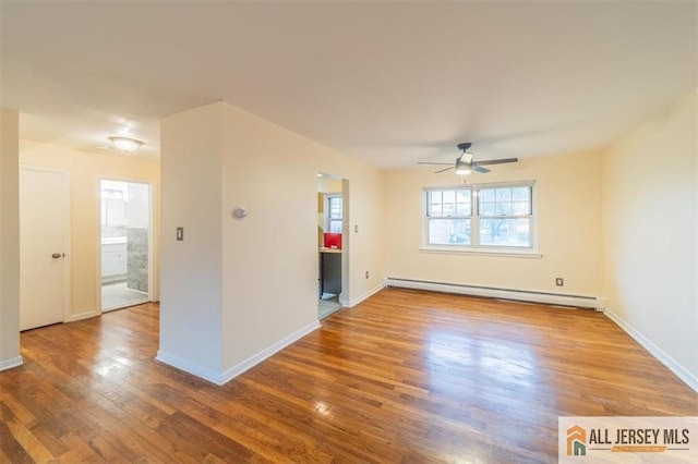 unfurnished room featuring a baseboard heating unit, a ceiling fan, wood finished floors, and baseboards