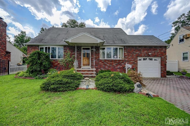 view of front of property featuring a front lawn, decorative driveway, fence, and brick siding