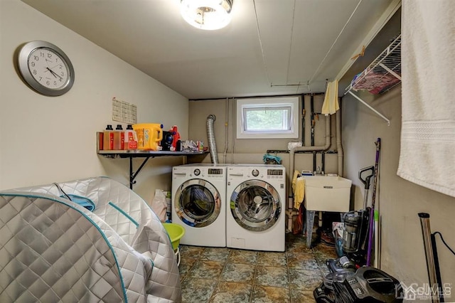 laundry area featuring washer and dryer, laundry area, stone finish flooring, and a sink