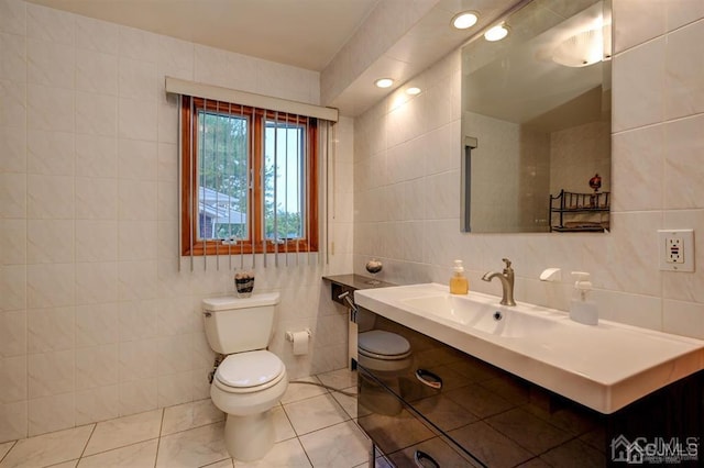 bathroom with vanity, recessed lighting, tile walls, toilet, and tile patterned floors