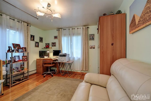 office featuring a baseboard radiator, wood finished floors, and a chandelier