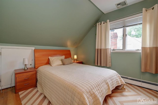 bedroom featuring visible vents, wood finished floors, lofted ceiling, and a baseboard radiator