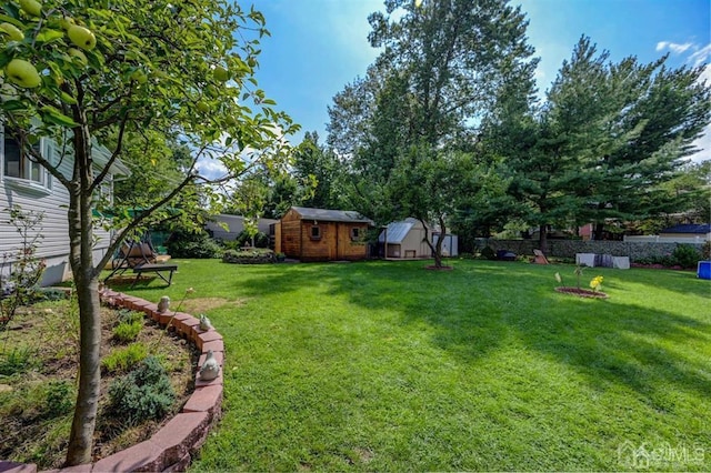 view of yard with an outbuilding, a storage shed, and fence