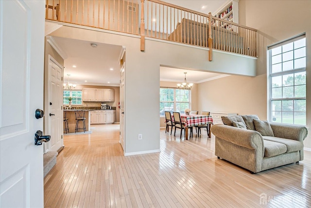 36 Jared Blvd, South Brunswick, NJ 08824 - living room with a chandelier, crown molding, light wood-style flooring, a high ceiling, and recessed lighting