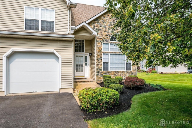 36 Jared Blvd, South Brunswick, NJ 08824 - view of front of house featuring stone siding, a front lawn, asphalt driveway, a shingled roof, and a garage