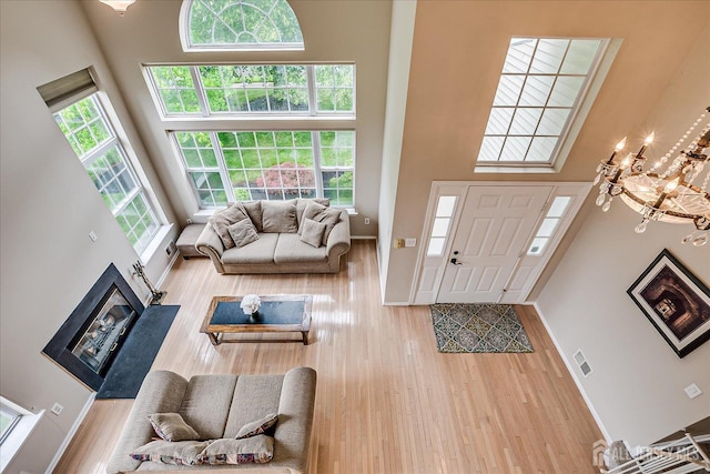 36 Jared Blvd, South Brunswick, NJ 08824 - living room featuring a high ceiling, wood finished floors, a glass covered fireplace, and a chandelier