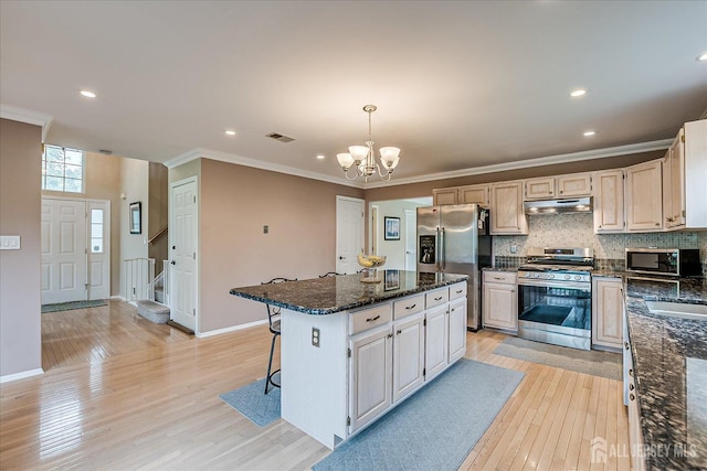 36 Jared Blvd, South Brunswick, NJ 08824 - kitchen with appliances with stainless steel finishes, under cabinet range hood, a chandelier, light wood-style floors, and a center island
