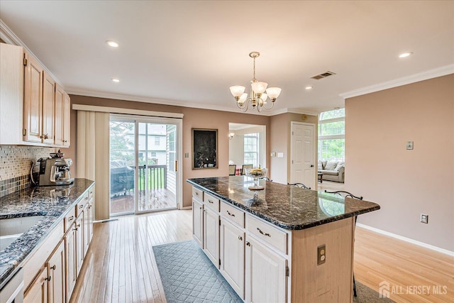 36 Jared Blvd, South Brunswick, NJ 08824 - kitchen featuring ornamental molding, a kitchen island, a chandelier, light wood finished floors, and tasteful backsplash