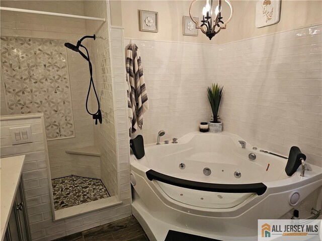 full bathroom with a whirlpool tub, a shower stall, tile walls, and wood finished floors