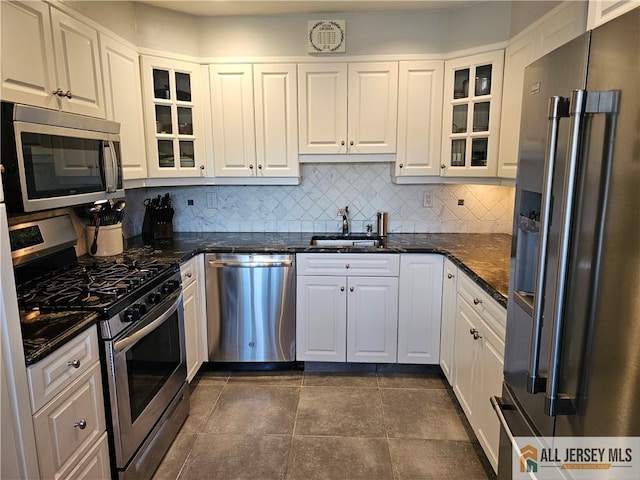 kitchen featuring stainless steel appliances, glass insert cabinets, and white cabinetry