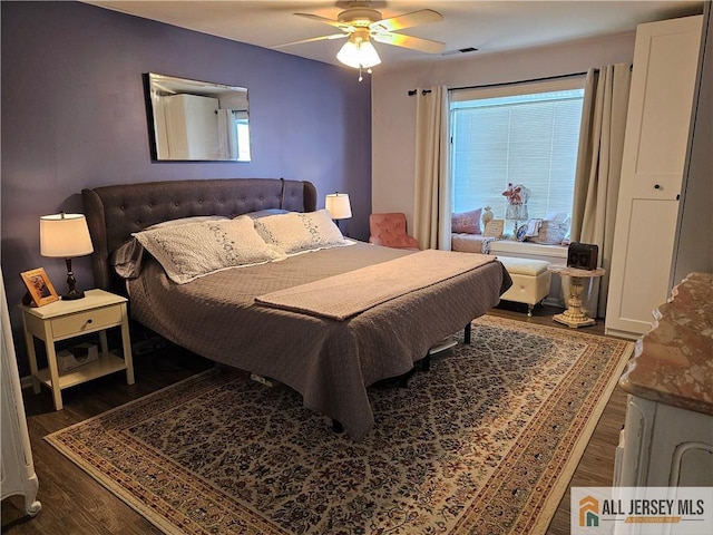 bedroom with ceiling fan, dark hardwood / wood-style flooring, and multiple windows