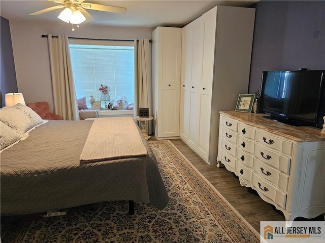 bedroom featuring dark hardwood / wood-style floors, ceiling fan, and a closet