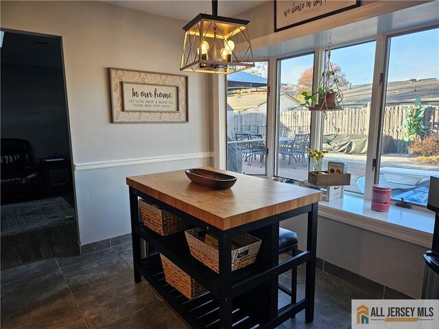 dining room with an inviting chandelier and dark tile patterned floors