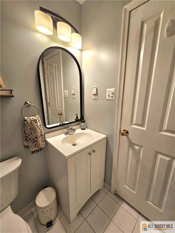 bathroom with vanity, tile patterned floors, and toilet