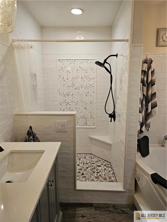 full bathroom featuring shower / bath combo, tile walls, and vanity