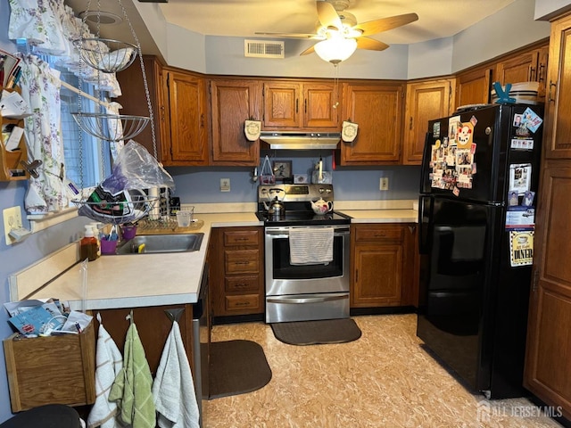 kitchen featuring brown cabinetry, visible vents, light countertops, under cabinet range hood, and appliances with stainless steel finishes