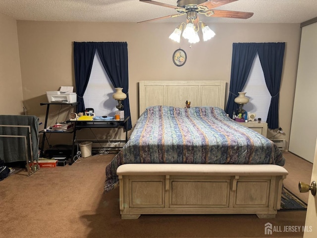 bedroom with ceiling fan, baseboard heating, carpet floors, and a textured ceiling