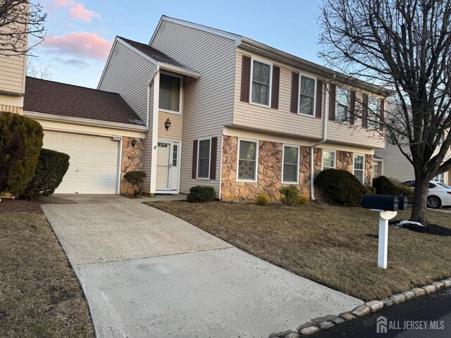 view of front of home with a garage and a lawn