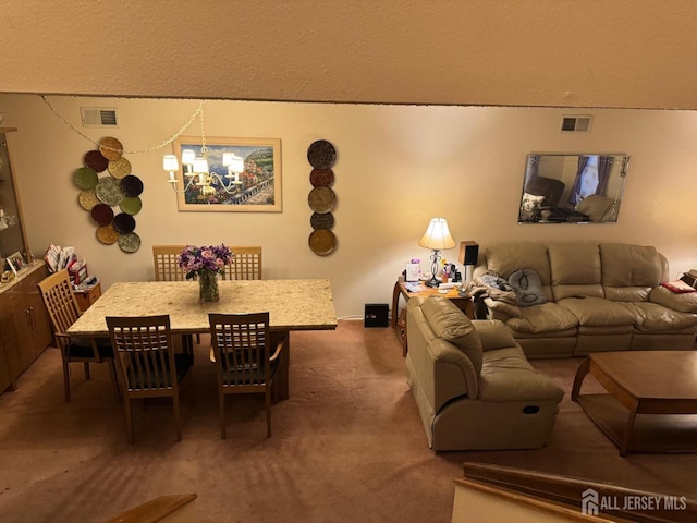 dining space with visible vents, an inviting chandelier, and carpet floors