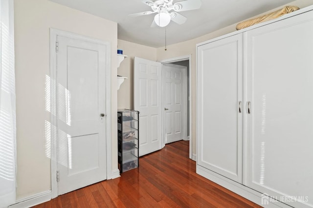 unfurnished bedroom featuring ceiling fan and dark wood-type flooring