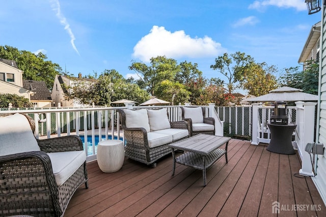 deck featuring an outdoor hangout area and a fenced in pool