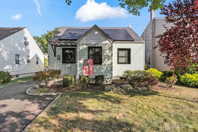 view of front of house featuring solar panels and a front yard