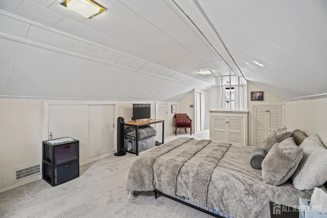 bedroom featuring vaulted ceiling and light colored carpet