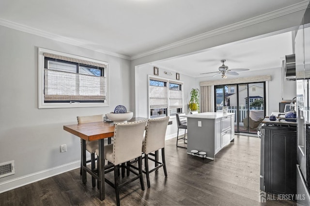 dining space featuring dark hardwood / wood-style flooring, ornamental molding, and ceiling fan