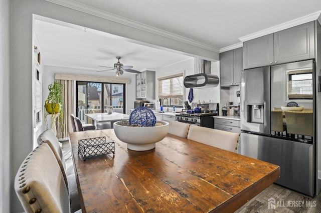 dining room featuring sink, crown molding, dark hardwood / wood-style floors, and ceiling fan