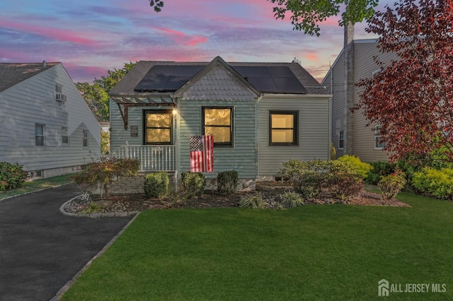 view of front of home featuring a lawn and solar panels