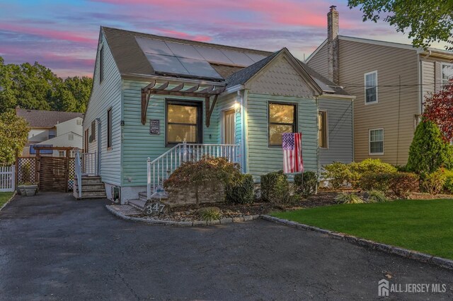 view of front of home with a yard and solar panels