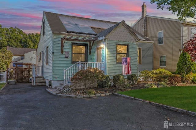 view of front of house featuring a lawn and solar panels