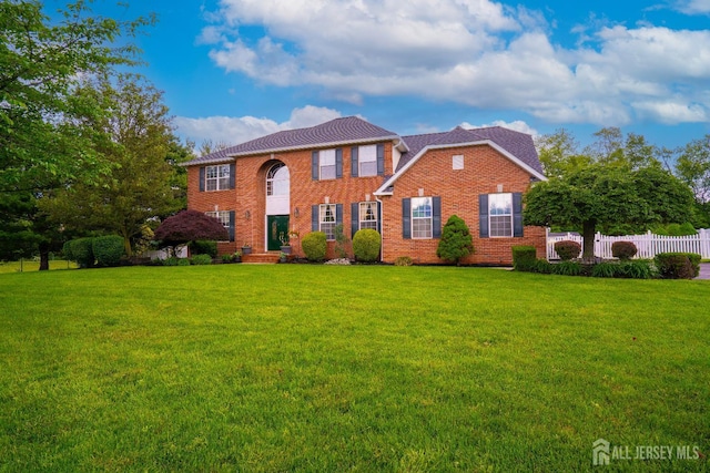 colonial-style house featuring brick siding
