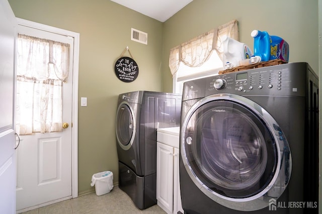 laundry room featuring washing machine and clothes dryer and light tile patterned floors