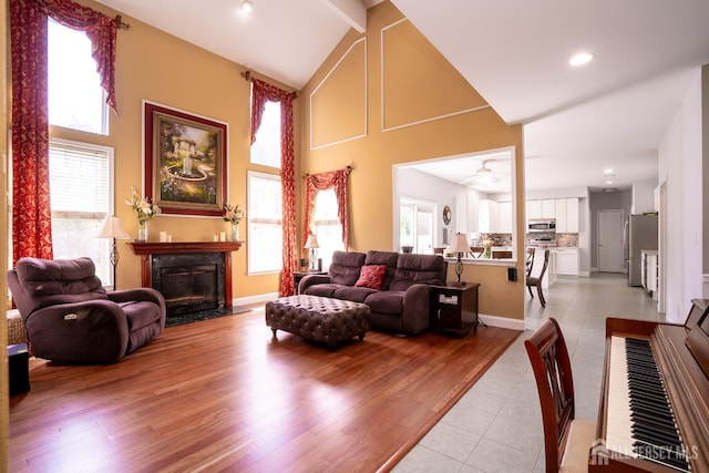 living area with a fireplace, high vaulted ceiling, a ceiling fan, recessed lighting, and light tile patterned floors