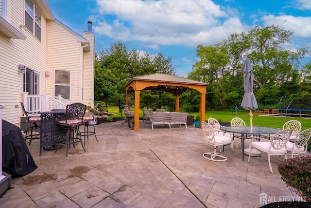view of patio / terrace with outdoor dining area, a gazebo, a trampoline, and an outdoor living space