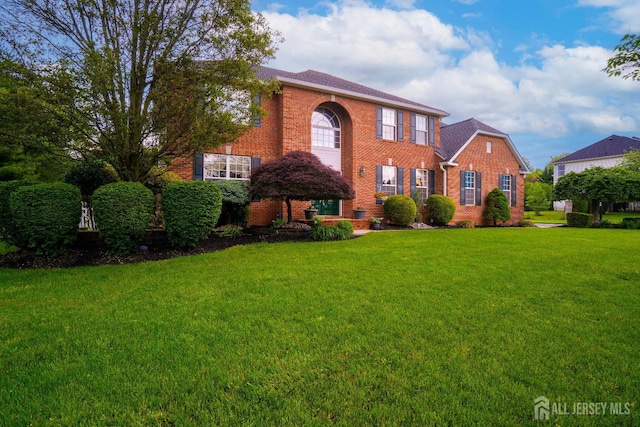 view of front of house featuring brick siding and a front yard
