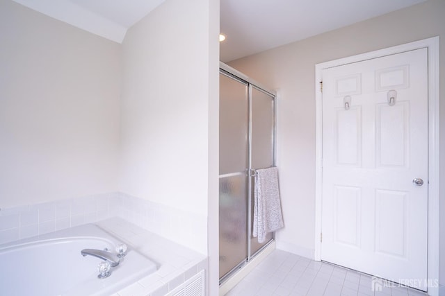 bathroom featuring tile patterned floors, a stall shower, and a bath