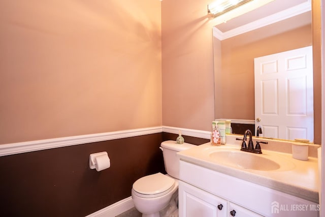 half bathroom featuring toilet, vanity, and baseboards