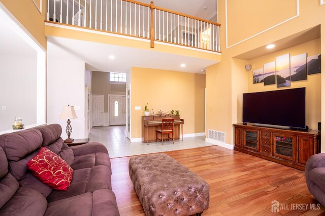 10 Magnolia Ct, Monroe, NJ 08831 - living area featuring a towering ceiling, wood finished floors, and baseboards